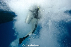 Bubbles surroundnig a diver after entering the water from... by Joe Graham 